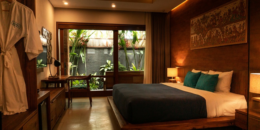 A lavish executive suite room with a view of a river from a glass window and other facilities.
