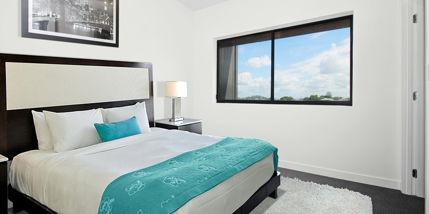 A lavish executive suite room with a view of a river from a glass window in Sinagpore.