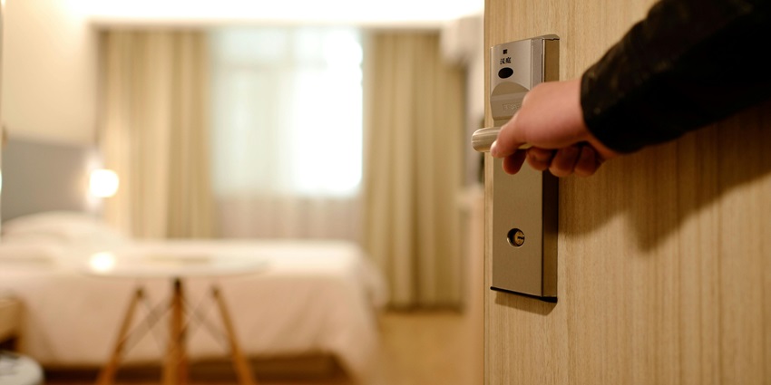A tourist opening the door of a room in a budget-friendly hotel in Sivasagar.