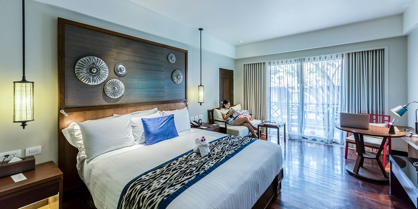 A cosy bedroom interior with modern decor, a neatly made bed, and soft lighting.