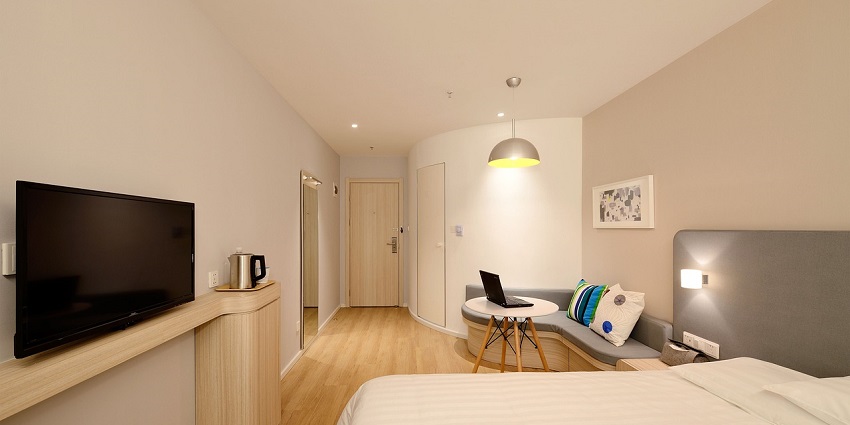 An image of a cosy and inviting hotel room with soft lighting and comfortable furnishings.