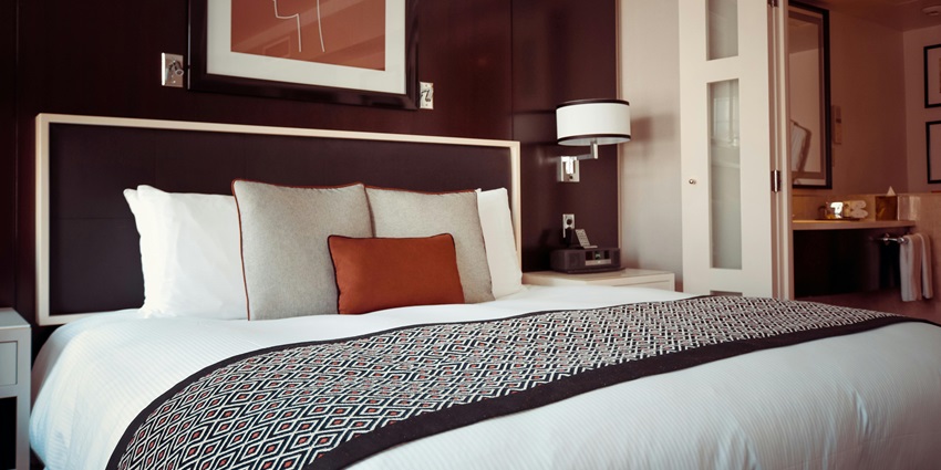 A lavish executive suite room with a view of a river from a glass window.