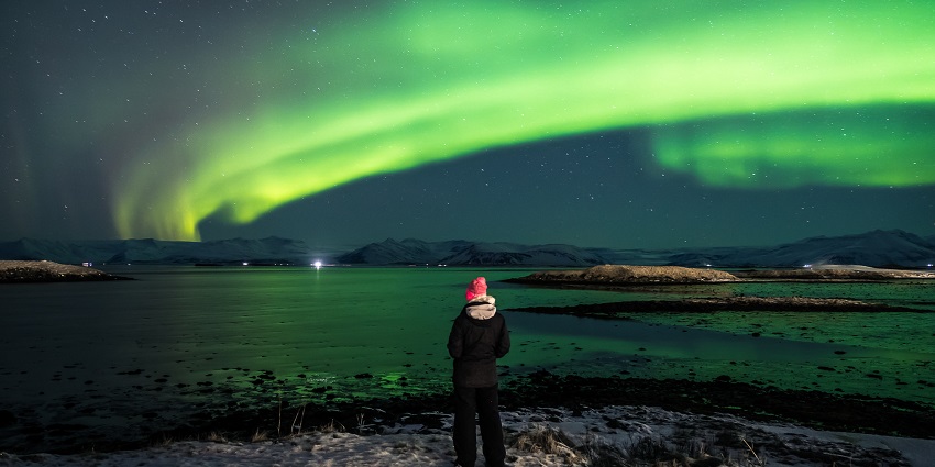 An image of a person enjoying the Northern Lights, a wonderful thing to see in Iceland