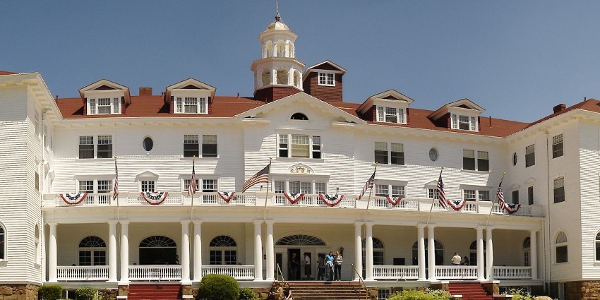 An image of The Stanley Hotel in Estes Park, Colorado on a bright, sunny, and cloudy day.