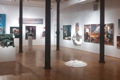 A picture of an Art Gallery in New York showcasing an exhibition on white walls.