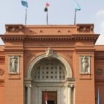 An outside view of the Egyptian Museum showcasing a few carved sculptures on its gate