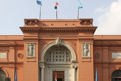 An outside view of the Egyptian Museum showcasing a few carved sculptures on its gate