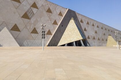 An outer structure of the Grand Egyptian Museum can be seen, covered in triangle glass.