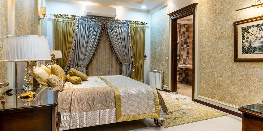 Image of a Luxury hotel room with comfortable bed and pillows also offering modern amenities