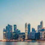 The official mascot of Singapore, is a lion, with tall skyscrapers in the background.