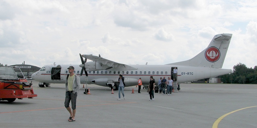 An image of Aalborg Airport, one of the airports in Denmark, featuring a plane on the runway.