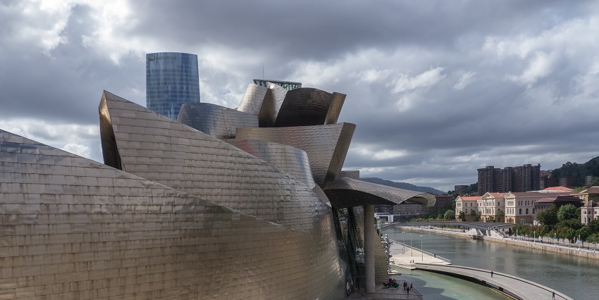 Visitors walk on a walkway at Guggenheim Museum, Bilbao, over the River Nervion.