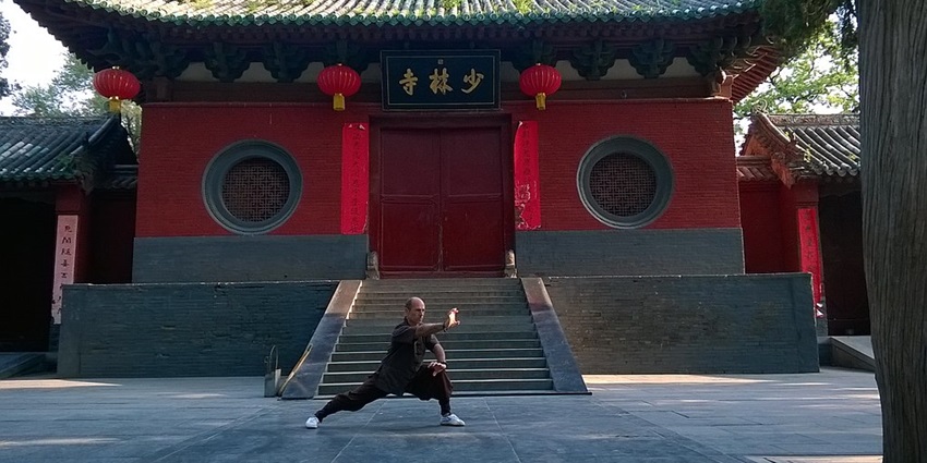 Ancient Shaolin Temple with traditional Chinese architecture surrounded by lush green trees