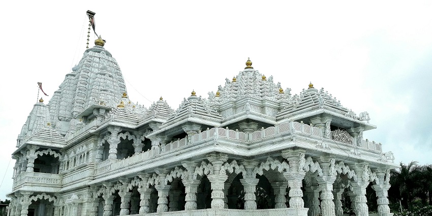 View of the Digambar Jain Temple, showcasing the detailed white  architecture in broad daylight.

