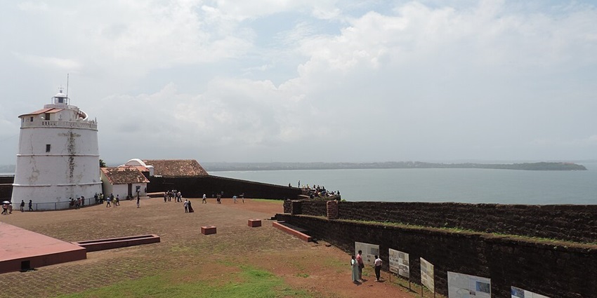 An image of Aguada fort with a lighthouse on the coastline, a famous sea fort in India.
