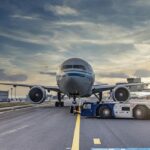 An image of an airport runway with the airplane getting ready to takeoff.