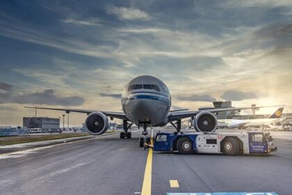 An image of an airport runway with the airplane getting ready to takeoff.