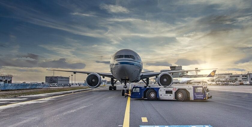 An image of an airport runway with the airplane getting ready to takeoff.