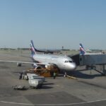 A modern airport in Russia with planes on the tarmac and a terminal in the background.