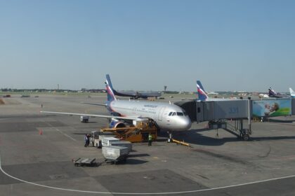 A modern airport in Russia with planes on the tarmac and a terminal in the background.