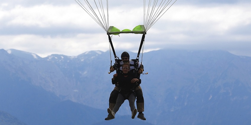 A tandem jump with a parachute illustrates the age limit for skydiving in Germany.