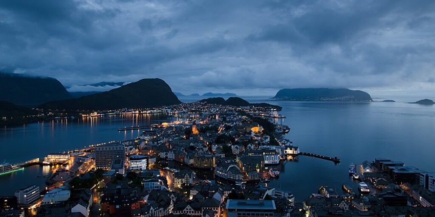 An image showing Ålesund, Norway, illuminated at night, showcasing its scenic beauty