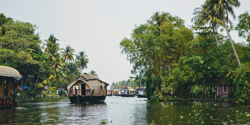 Boat with a thatched roof in Alleppey, Kerala, one of the good places to visit in October in India for couples