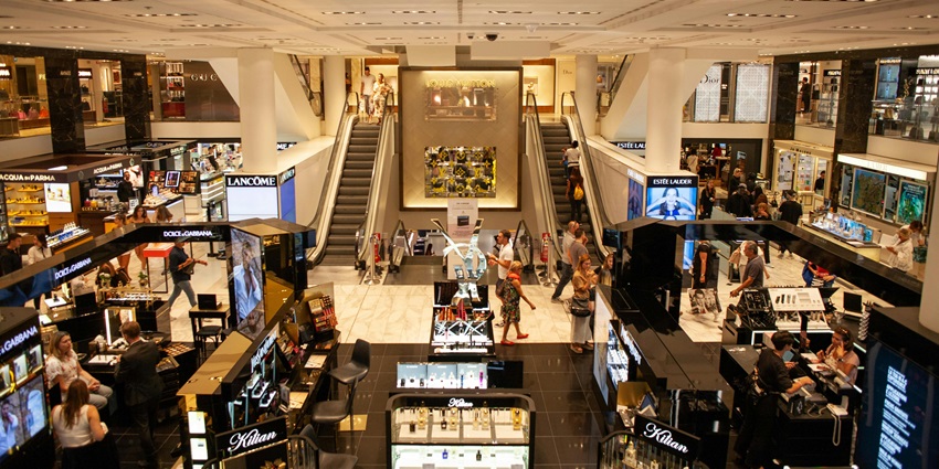 An image of a shopping mall during the holidays, decorated with festive lights and ornaments everywhere.