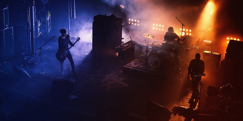 Live music setup with a band performing on stage similar to the vibe of Apollo Live Club.