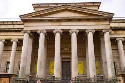 A view of the Manchester Art Gallery showcasing its grand entrance and people entering