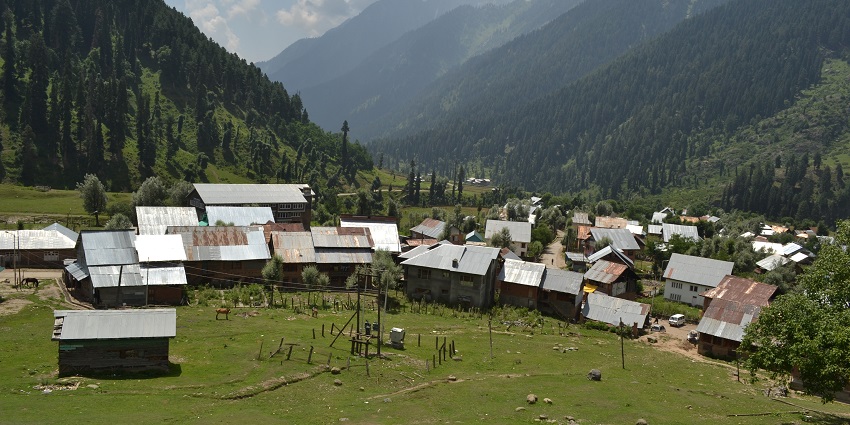 An image showing Aru Valley in Jammu & Kashmir, surrounded by hills and open green spaces.