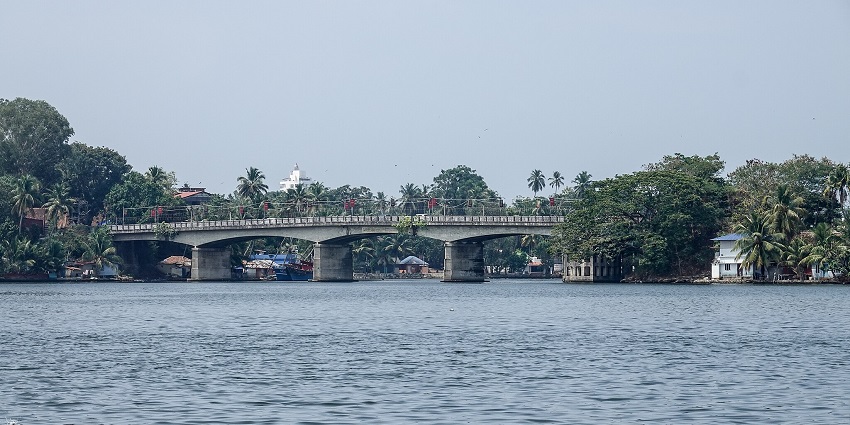 An image of a trevally bridge over Ashtamudi Lake, reflecting on the water.