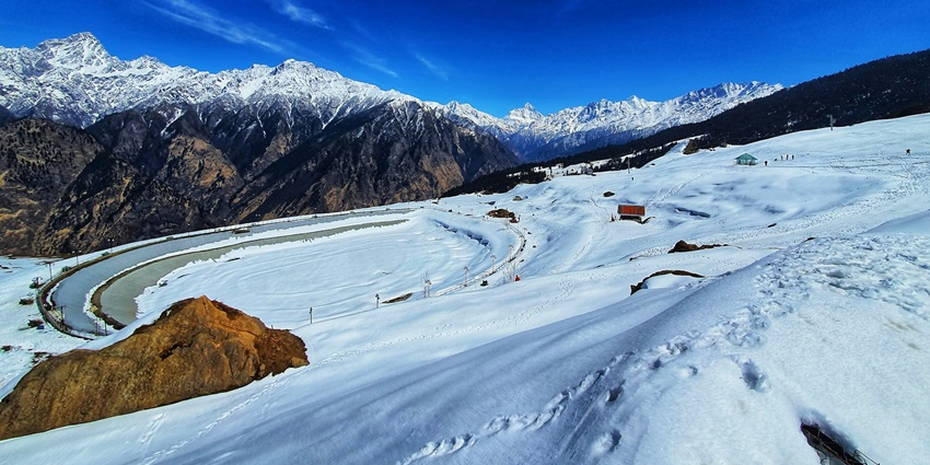 An image of the Auli Hill Station, with snowy landscape all around.