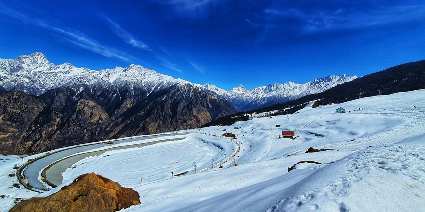 An image of the snowy landscape of Auli in the mountains, a breathtaking vista.