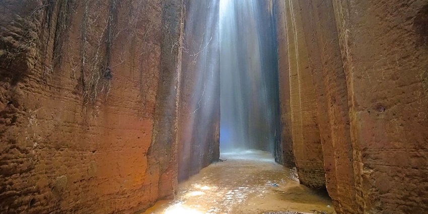 Unique Nigerian waterfall emerging from limestone rocks, believed to have spiritual significance and healing properties.