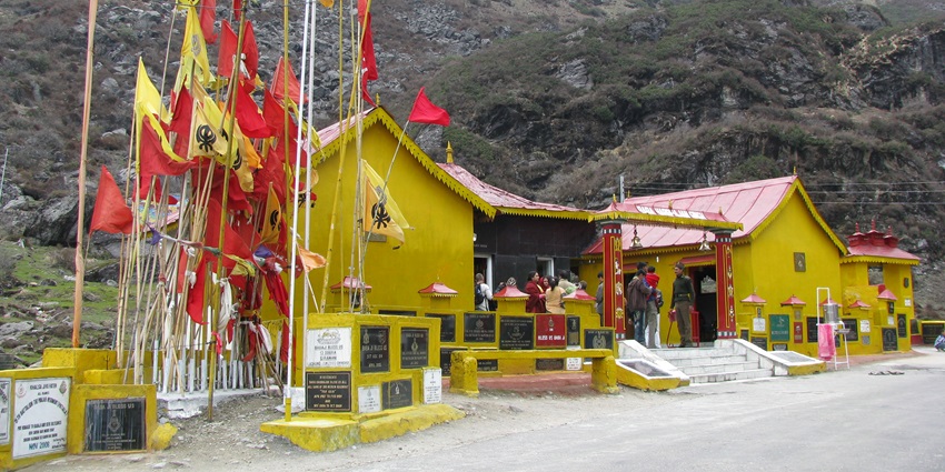 Baba Harbhajan Singh temple with yellow walls, officers standing at a distance and flags