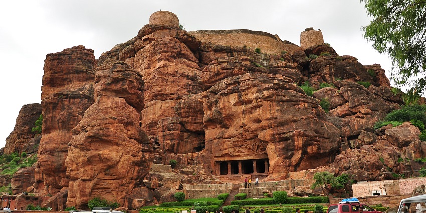 A view of the ancient Badami Cave Temples in Karnataka, carved into sandstone cliffs.