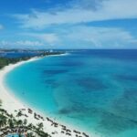 Pristine white sand and beach water, one of the Bahamas beaches, with turquoise waters and swaying palm trees