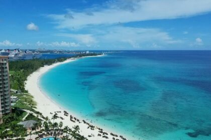 Pristine white sand and beach water, one of the Bahamas beaches, with turquoise waters and swaying palm trees