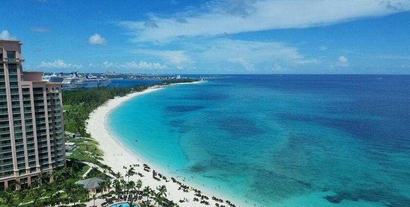 Pristine white sand and beach water, one of the Bahamas beaches, with turquoise waters and swaying palm trees