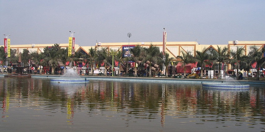 A peaceful view of Ballabgarh Lake, with reflections of trees on the water's surface.