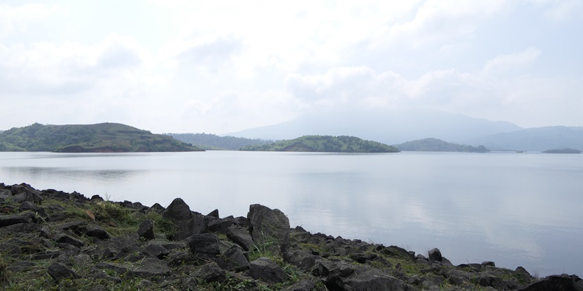 A view of Banasura Sagar Dam surrounded by lush greenery and hills in the background