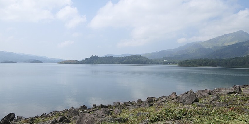 Banasura Sagar Dam with a very large water body, green shorelines and green mountains.
