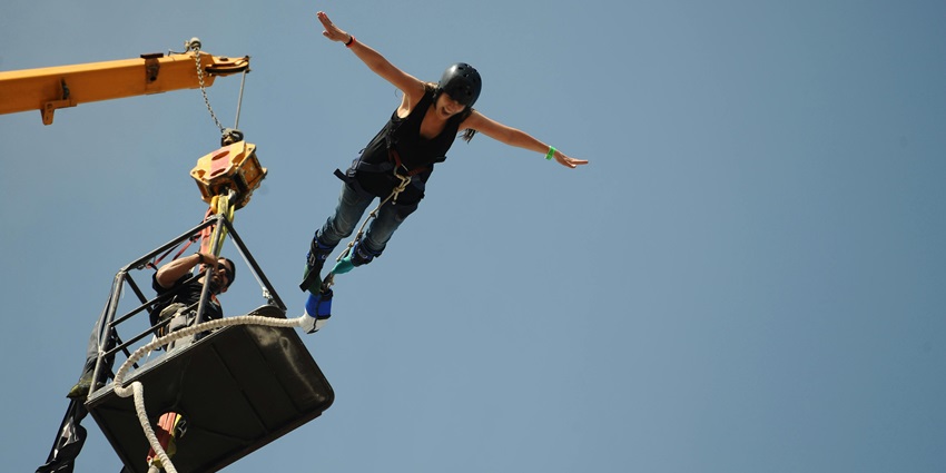 A woman bungee jumping from a crane, similar to the bungee jumping in Bangalore.