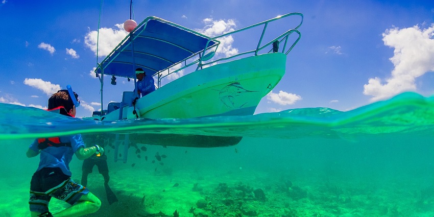 A kid snorkelling underwater in clear blue water similar to snorkelling in India