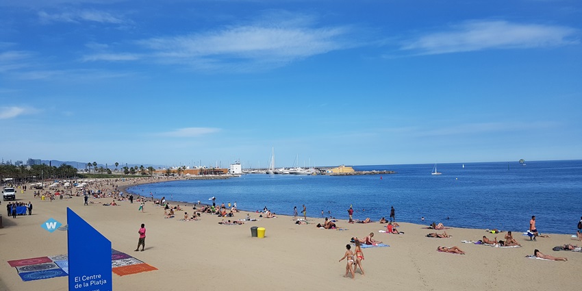 A breathtaking view of Barcelona’s pristine coastline and people strolling around