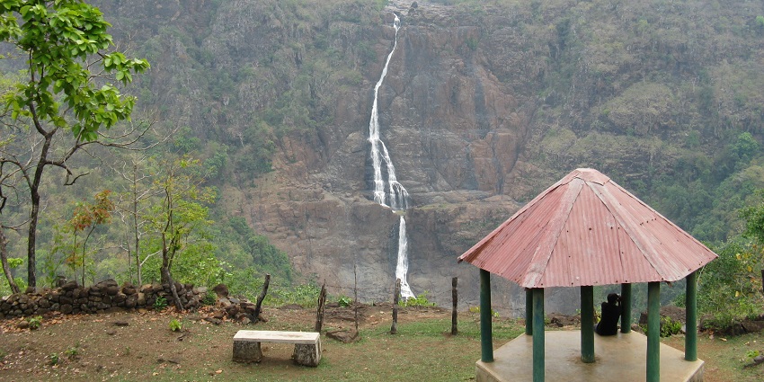 An image showing Barehipani Falls cascading down a rocky cliff in multiple tiers.