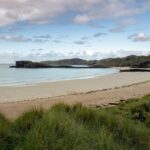 Beaches in Scotland feature rugged cliffs, golden sands, and turquoise waters.