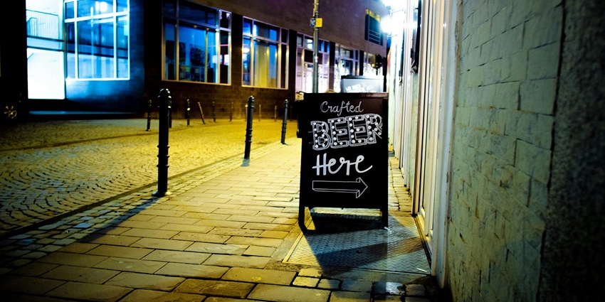 Signage of the Beer Gardens with the view of the street ahead.