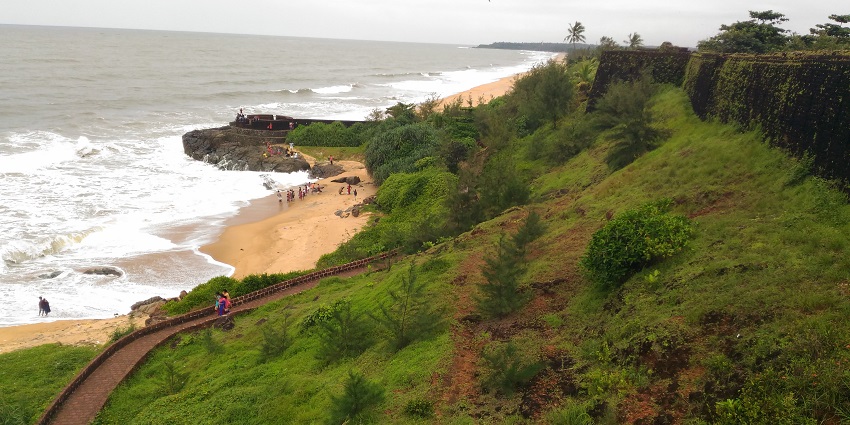 An image showing the sea beach and the walls of the Bekal Fort, a famous historical building.